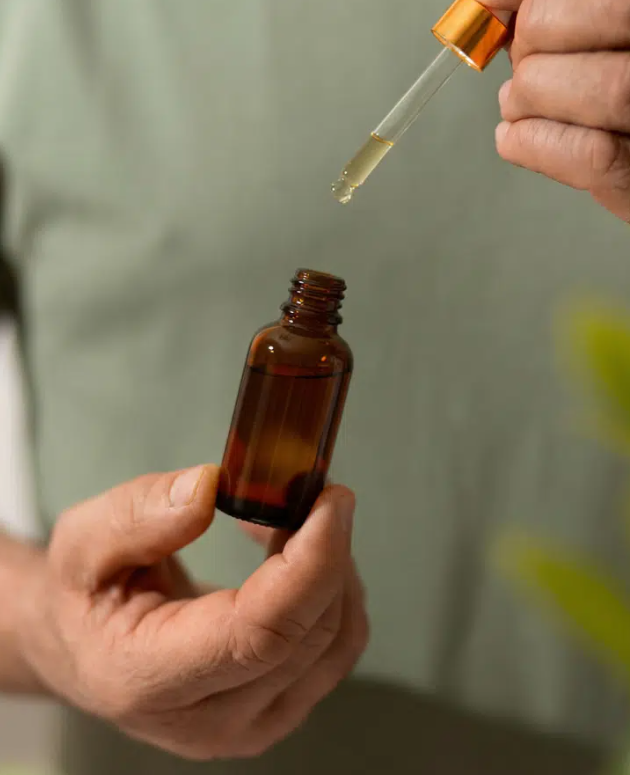 Conta-gotas com óleo medicinal sobre folhas de cannabis